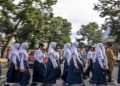 Sejumlah pelajar didampingi petugas Dinas Perhubungan (Dishub) Kota Cimahi menyeberang jalan di Pelican Crossing di Jalan Gatot Subroto, Kota Cimahi, Jawa Barat, Senin (19/1/2026). Dinas Perhubungan (Dishub) Kota Cimahi melakukan uji coba dan sosialisasi penggunaan Pedestrian Light Controlled Crossing (Pelican Crossing) sebagai upaya menciptakan jalur aman untuk menyeberang serta mengurangi risiko kecelakaan.